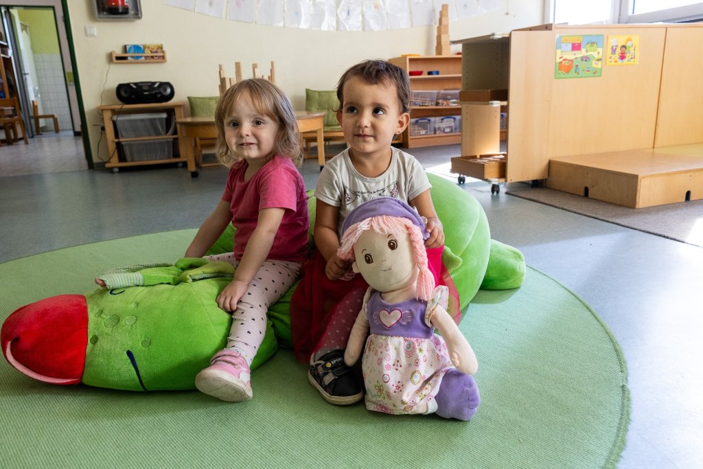 Kinder mit Puppe und Kuscheltier