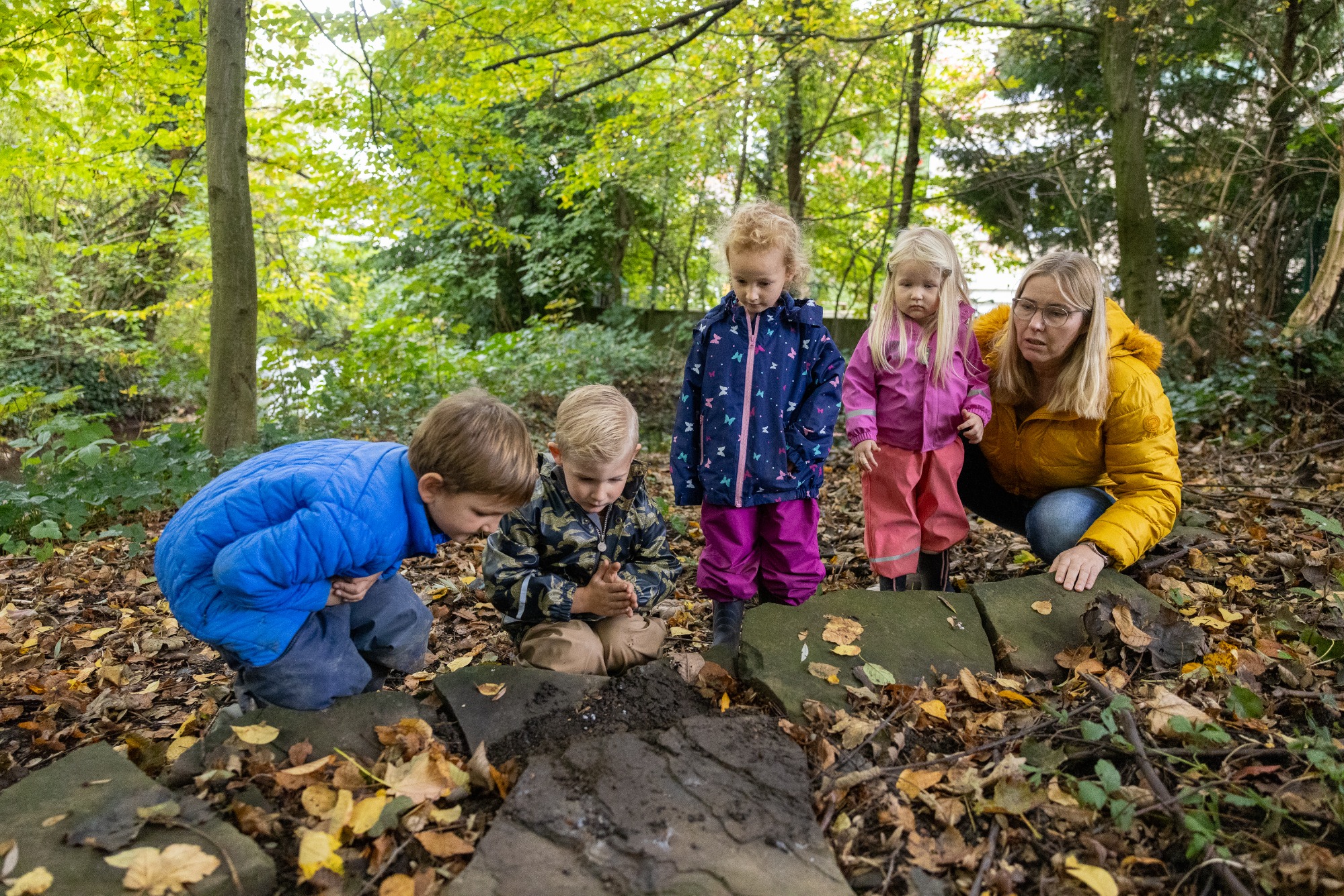 Kindergruppe mit Erzieherin im Wald