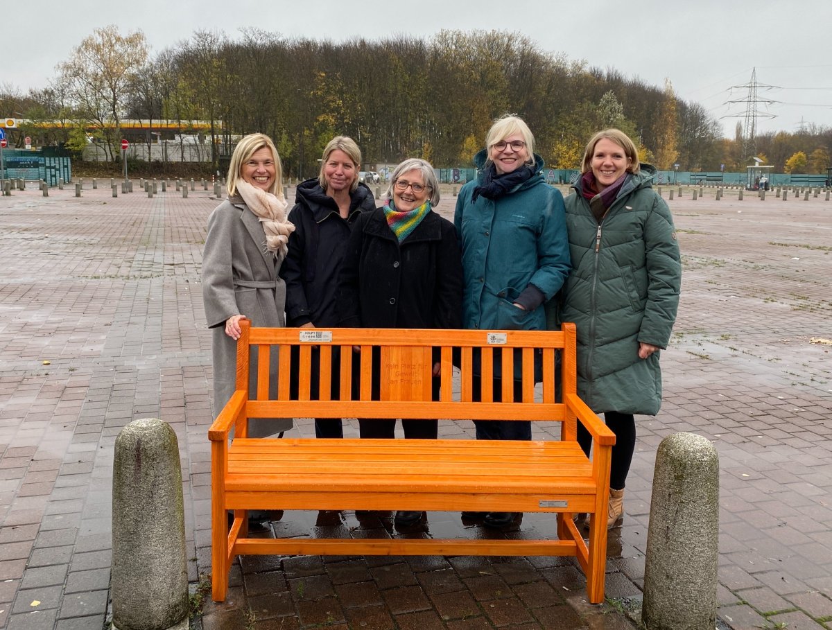 Frauen hinter orangener Bank