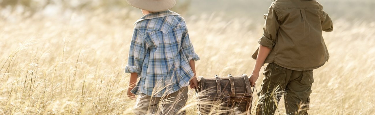 Kinder mit Schatzkiste in einem Getreidefeld